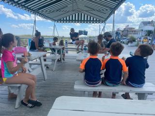 children listening to a book being read at the beach pavillion